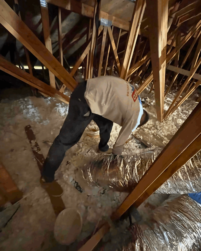 a Certified tech working in an attic and installing ductwork