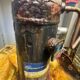 This heavily rusted Copeland Scroll compressor indoors, covered in warning labels, clearly needs expert AC repair in Fort Myers.