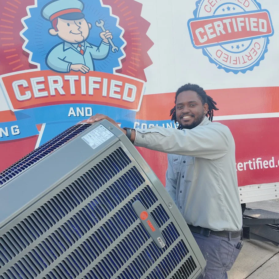 A uniformed technician smiles while standing next to an air conditioning unit, and a "Certified" service truck is visible behind him.