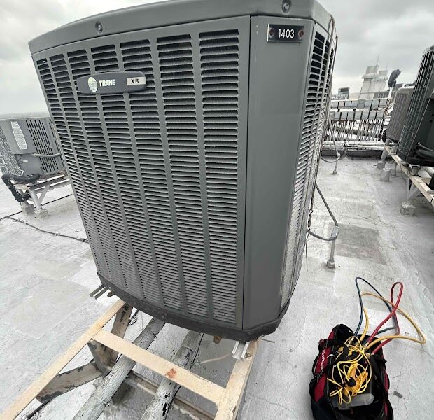 En la azotea hay una gran unidad de aire acondicionado Trane XE. Las herramientas y los cables de colores que hay en una bolsa cerca te recuerdan que debes apagar el aire acondicionado durante las tormentas.